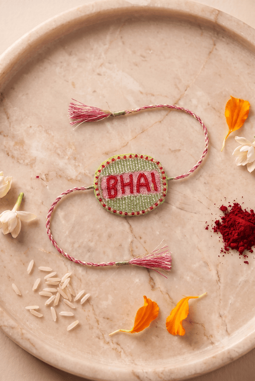 Beautifull handcrafted Green and Silver Embroidered Rakhi with Pink Braded Thread Tassels