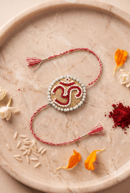 Om Motif Embellished with Red, White, and Golden Beadwork Rakhi