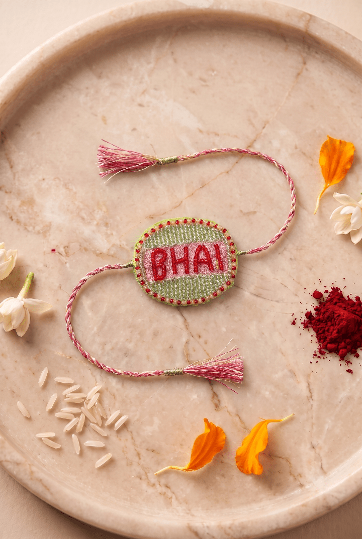 Beautifull handcrafted Green and Silver Embroidered Rakhi with Pink Braded Thread Tassels - Western Era Rakhi for women