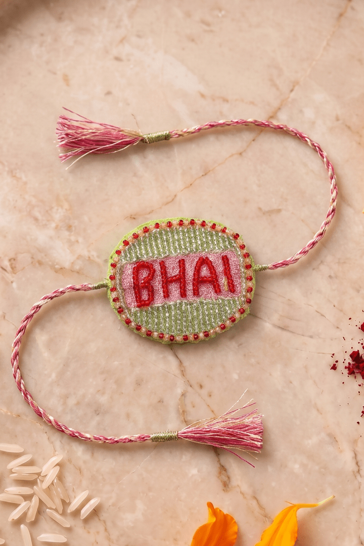 Beautifull handcrafted Green and Silver Embroidered Rakhi with Pink Braded Thread Tassels - Western Era Rakhi for women