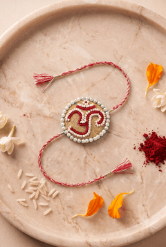 Om Motif Embellished with Red, White, and Golden Beadwork Rakhi - Western Era Rakhi for women